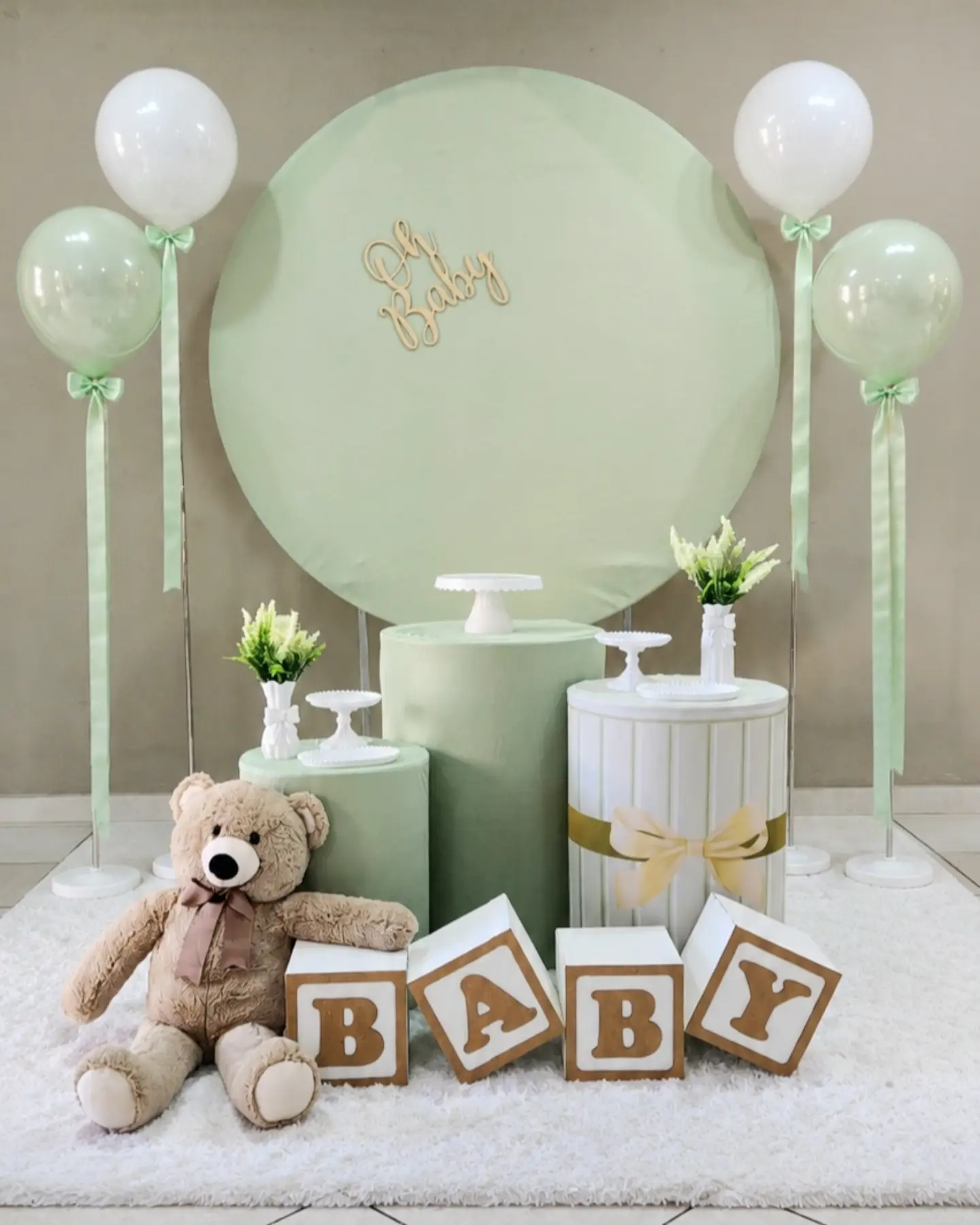 Kit Encanto verde visto de frente, com painel arco, ursinho e cubos BABY