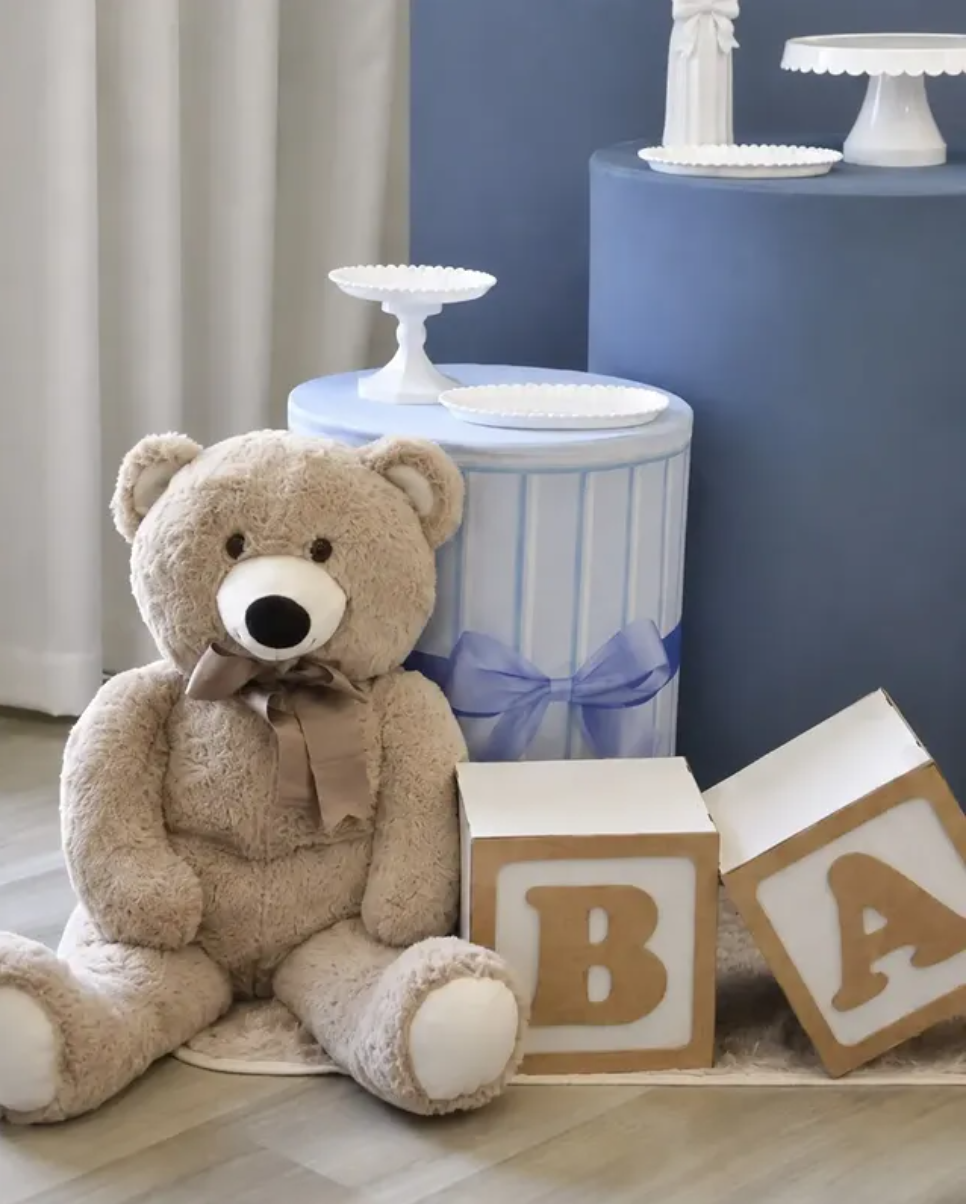 Ursinho com laço azul ao lado dos cubos BABY