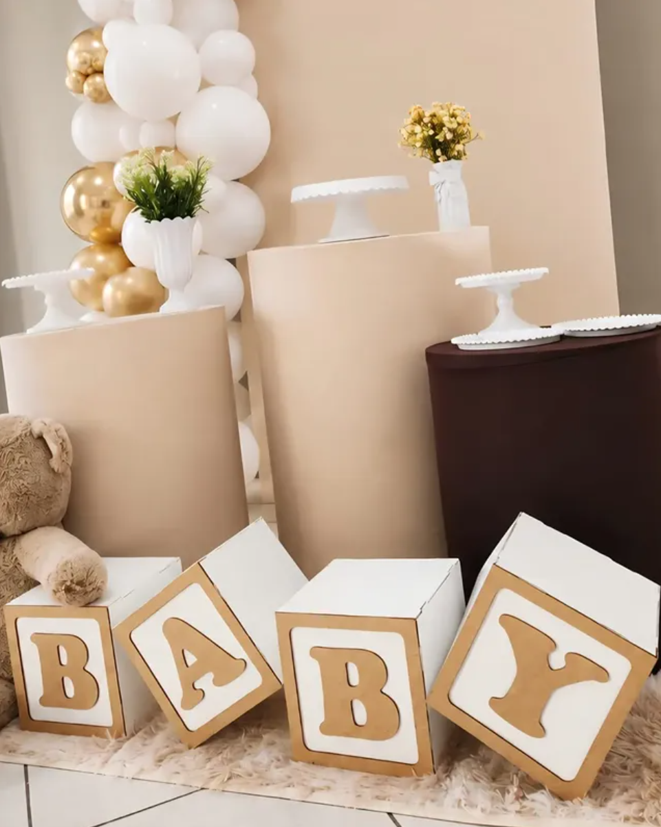 Cubos BABY em dourado diante dos cilindros bege