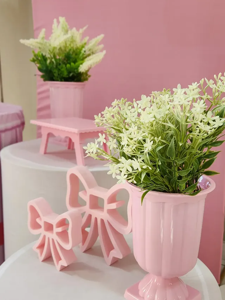 Laços rosa decorativos e vaso com flores brancas